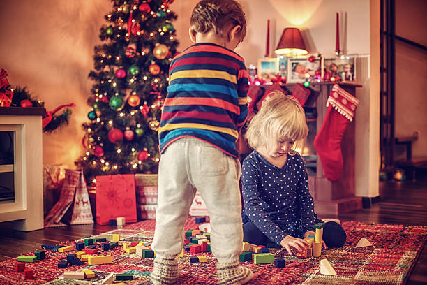 istock Adorable Kids Playing in in front of Christmas Tree 493930454