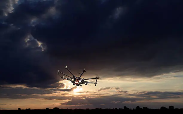 Flying copter with their gear on the background of a beautiful sunset.