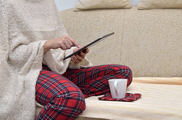 istock Woman in home wear reading on tablet 493933460