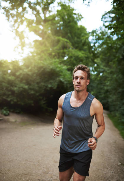 istock Jogger running through a wooded park 493933982