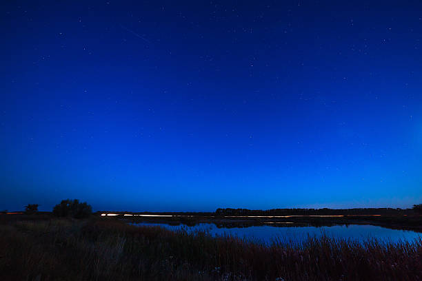 istock stars in  night sky reflected in the river. 493934720