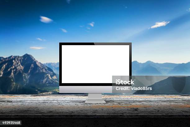 Computer Display On Desk With Mountain In The Background Stock Photo - Download Image Now