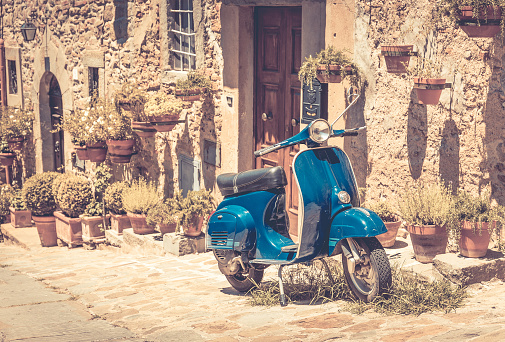 Scooter in front of old building in Cortona town, Tuscany