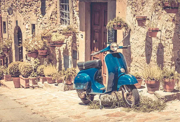 Scooter in front of old building in Cortona town, Tuscany