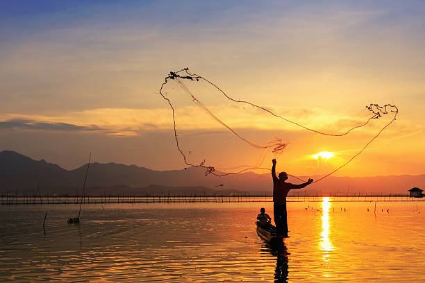 istock throwing fishing net during sunset 493952389