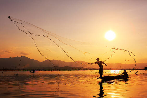 istock throwing fishing net during sunset 493952781