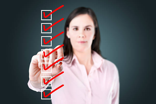 istock Young business woman checking on checklist boxes. 493954357
