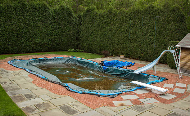 istock Backyard In ground Pool with a Dirty Cover Over It 493955339
