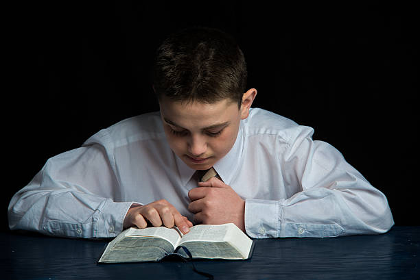 teen jovem rapaz estudar a scriptures - bible holding reading book imagens e fotografias de stock