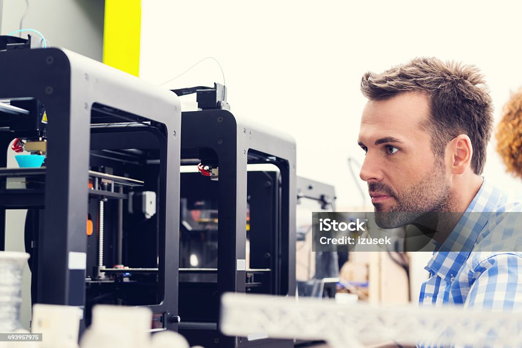 3D printer office Man working in a 3d printer office, watching at 3d printout. 3D Printing Stock Photo
