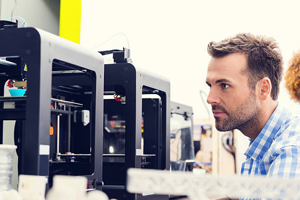 3D printer office Man working in a 3d printer office, watching at 3d printout. 3d printing filament photos stock pictures, royalty-free photos & images