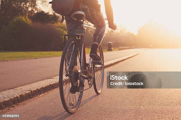 Young Woman Cycling In The Park At Sunset Stock Photo - Download Image Now - Cycling, Bicycle, City