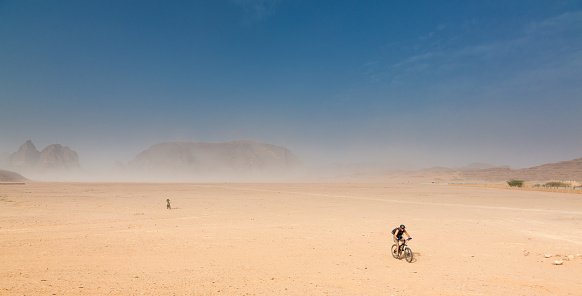 A couple is crossing the Jordan Desert plains after a sandstorm.