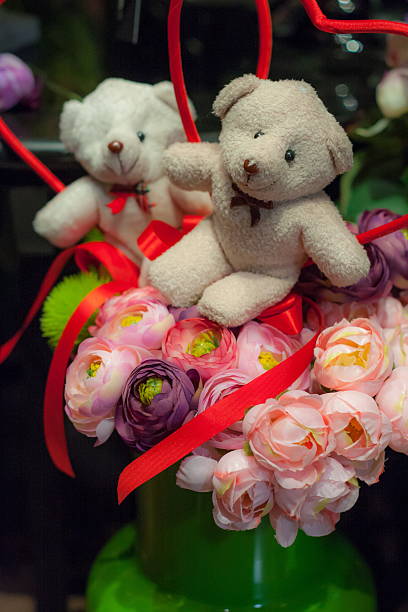 istock teddy bear is sitting on top of the flowers 493959831