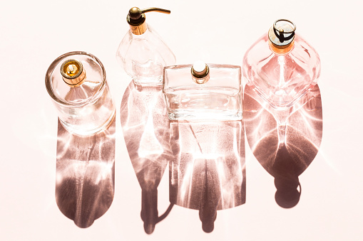 Perfume bottles on a bright light with the shadows