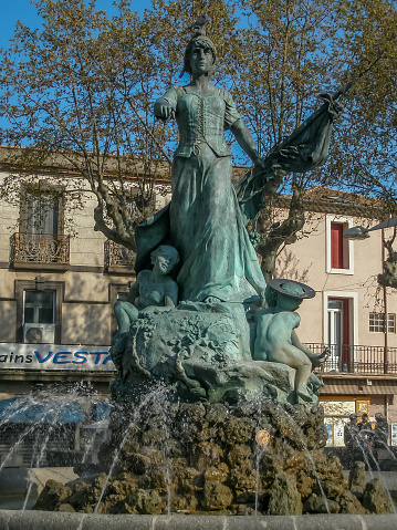 A green patena on a statue in the square in Agde , France.