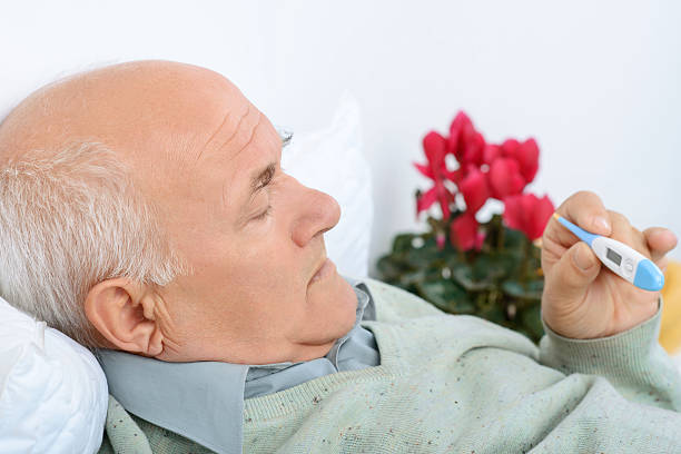 istock Senior gentelman checks the thermometer with a light scowl 493973188