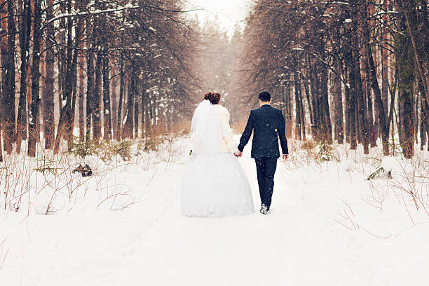 bride and groom in the winter woods bride and groom in the winter woods. flower outdoors day loving stock pictures, royalty-free photos & images