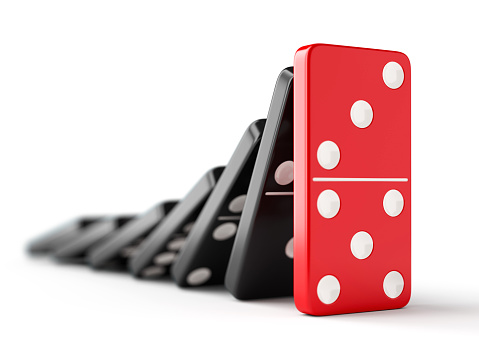 Unique red domino tile stops falling black dominoes. Leadership, teamwork and business strategy concept.