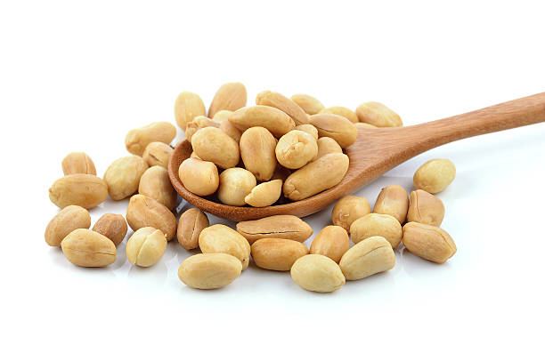 istock peanuts in the wood spoon on white background 493977706