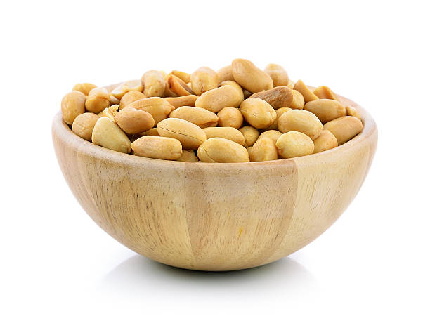 istock peanuts in a wood bowl on white background 493977736