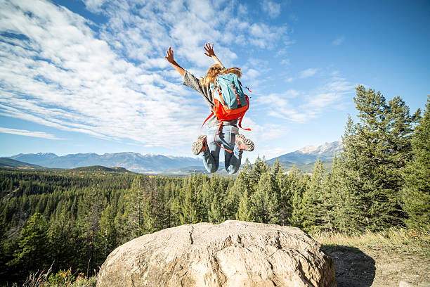 istock Cheering hiker jumping high up in the air 493978650