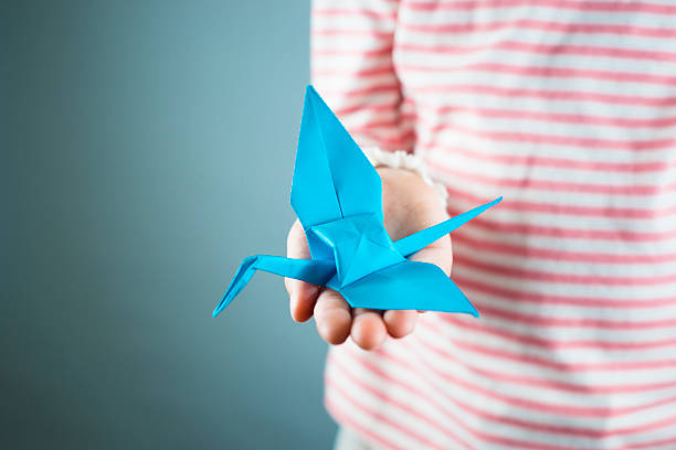 istock Origami crane in childs hand 493978779