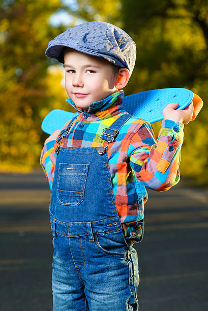 istock Smiling boy holding color plastic penny board skateboard outdoor 493979520