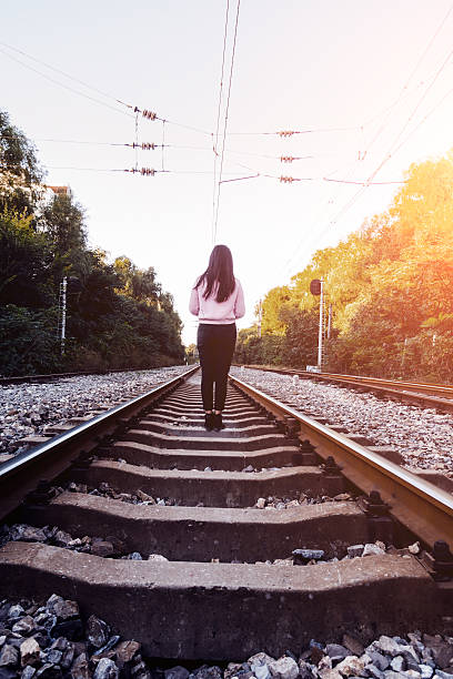 молодая женщина, стоя на железной дороги - railing beautiful human leg people стоковые фото и изображения