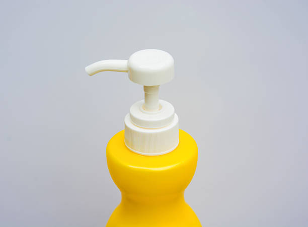 istock White Injection Push Button of the yellow shower-gel bottle 493980798