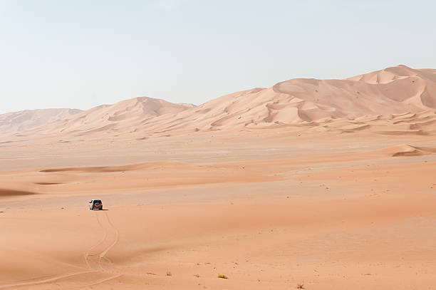 Car among sand dunes in Oman desert (Oman) stock photo