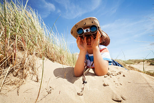 bambino esploratore sulla spiaggia - searching child curiosity discovery foto e immagini stock