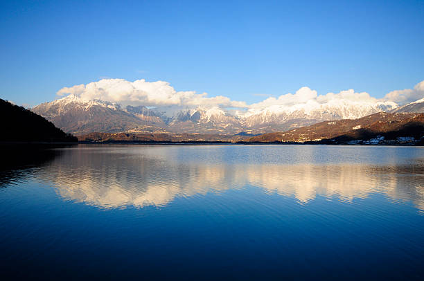 Reflected mountains Perfect reflections of snowy mountains in a blue lake piazza di santa croce stock pictures, royalty-free photos & images