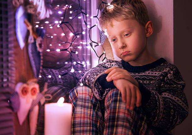 triste niño pequeño espera para navidad presenta - christmas window santa claus lighting equipment fotografías e imágenes de stock