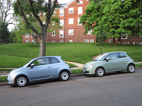 Washington DC, USA-May 17, 2014: These brand new light blue and pale green Fiat 500 automobiles were spotted in a quiet Washington DC neighborhood. A 101 horse power 4 cylinder engine powers the car delivering 31 mpg in the city and 40 mpg on the highway.