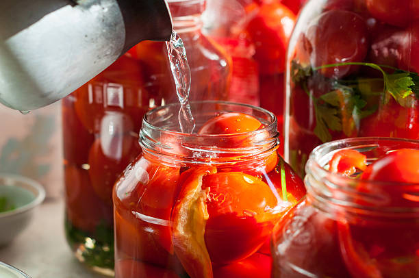 istock Canning process of tomato in mason jar. On background is 493996746