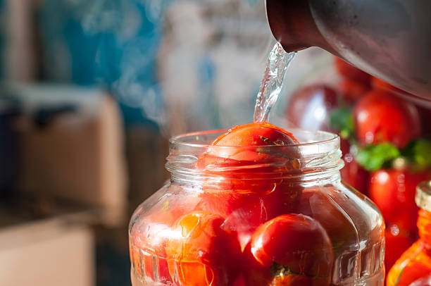 istock Canning process of tomato in mason jar. On background is 493996756