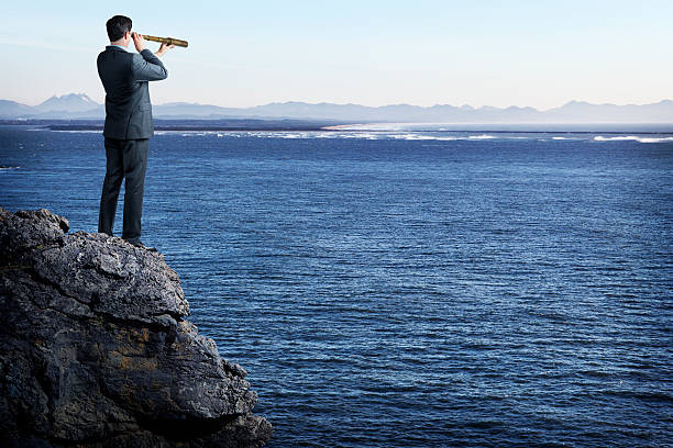 istock Businessman standing on cliff looking out to sea 493997411