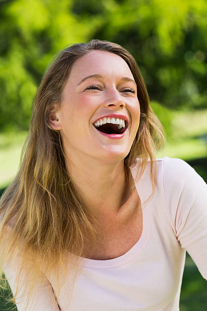 istock Cheerful young woman laughing in park 493998055
