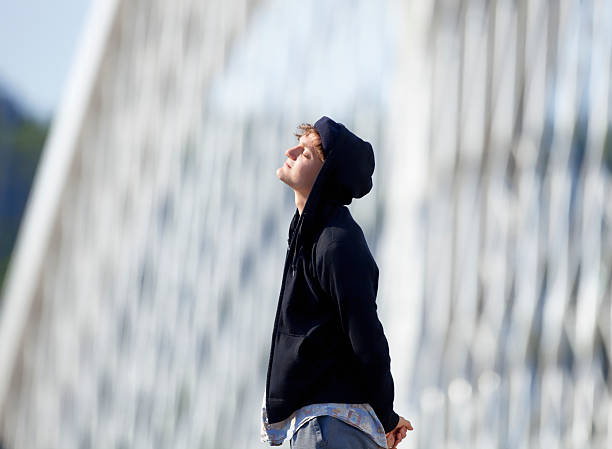 istock Young Man with Hood Standing on the Bridge 494000772