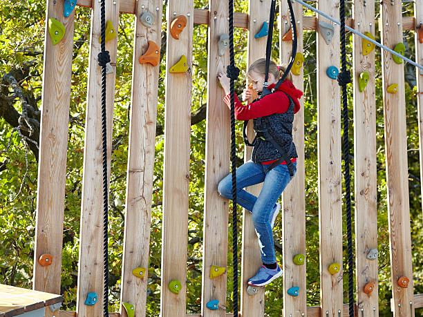 Girl athlete runs an obstacle course in climbing amusement park