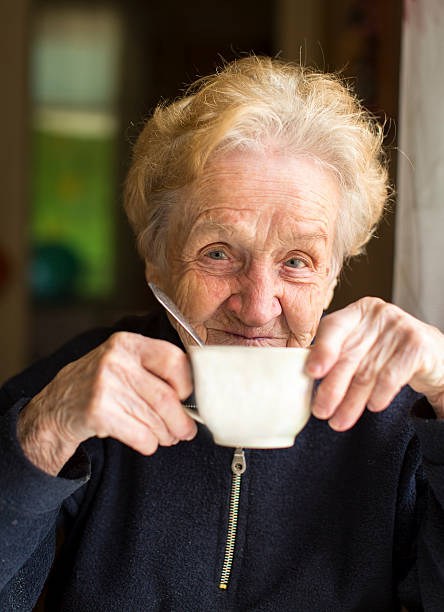 istock Old woman sits drinking tea, a portrait 494002562