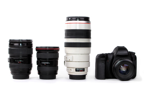 Three lenses - zoom lens, wide angle and a telephoto lens with a dslr camera isolated on white background.
