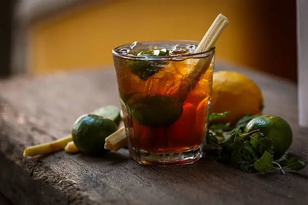 Cocktail glass on wooden table with lime and lemon