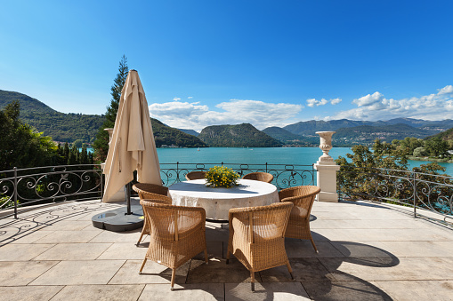 external of a luxury mansion, beautiful terrace overlooking the lake