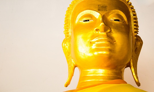 Golden Buddha face in candlelight