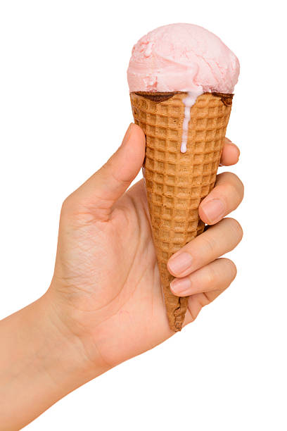 Hand holding strawberry ice cream cone isolated on white background