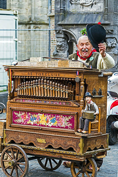 Old man with traditional belgian hurdy-gurdy Bruges, Belgium - October 13, 2015: Old man with traditional belgian hurdy-gurdy, on a street in Bruges, Belgium. hurdy gurdy stock pictures, royalty-free photos & images