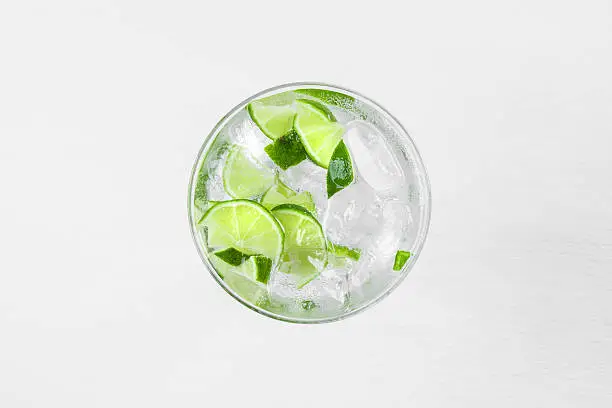 Fresh cocktail with lime slices on white background