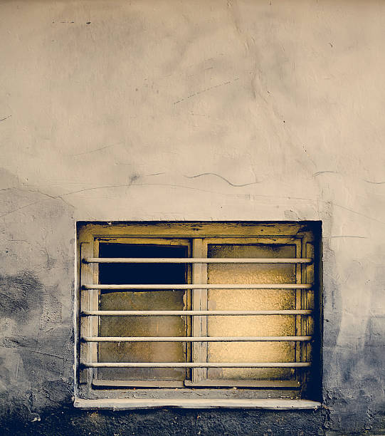 istock Dirty old window with bars on a grungy building 494037720